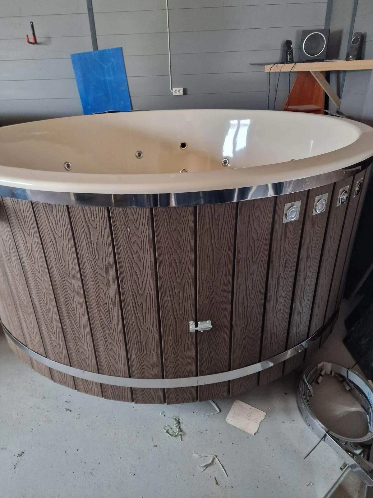 Badestamp med kremhvitt kar og brun kledning med trestruktur, i verkstedet