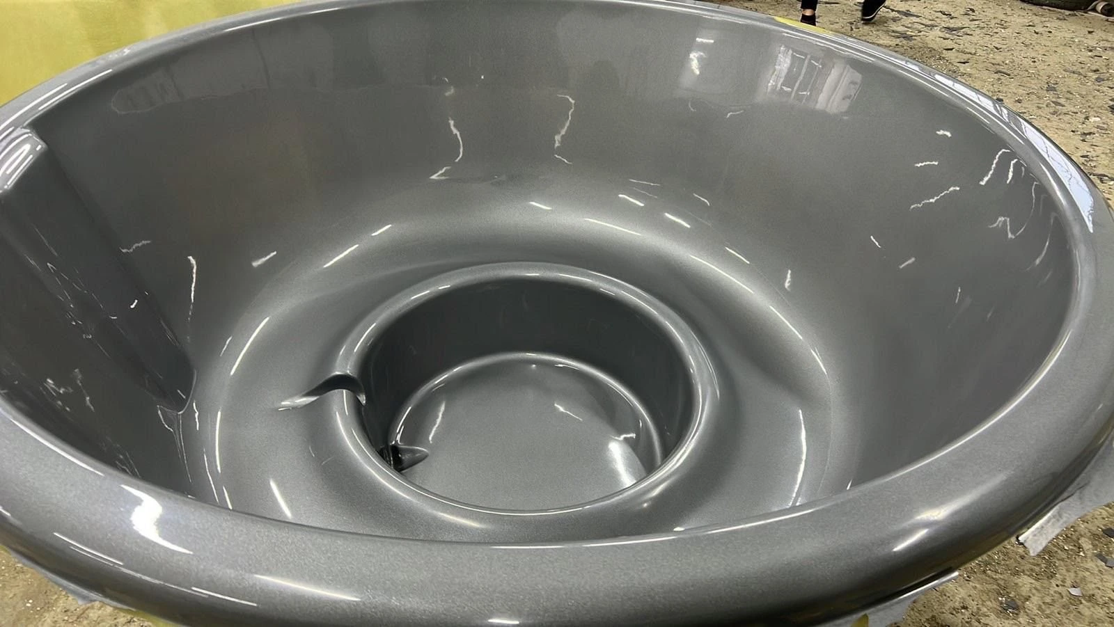 Grått badestampkar med sete og dyp fotbrønn, i verkstedet