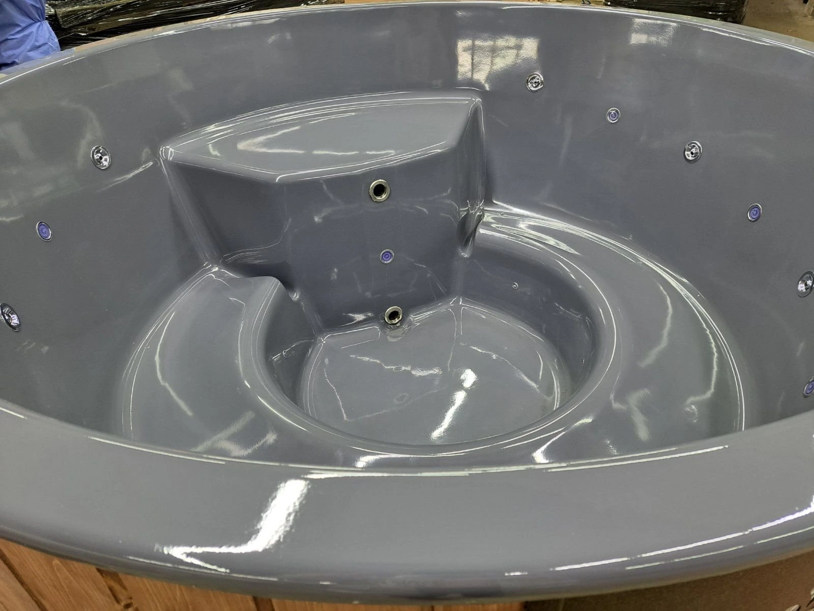 Grått badestampkar med sete og dyser i verkstedet