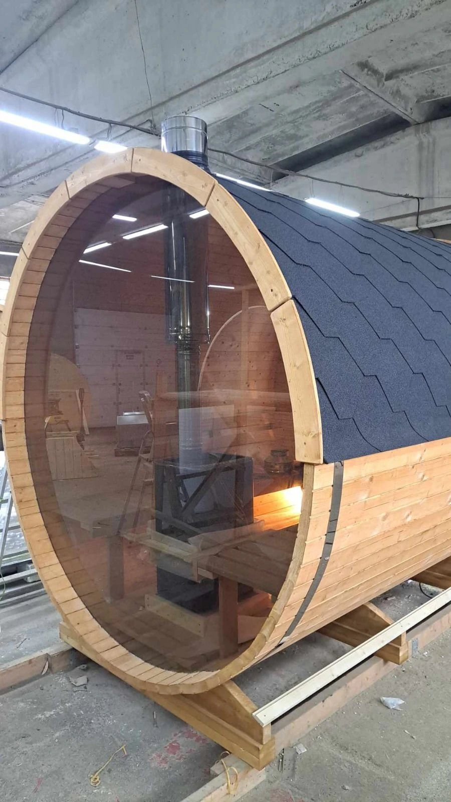 Tønnebadstue med glassgavl og vedovn synlig innenfor