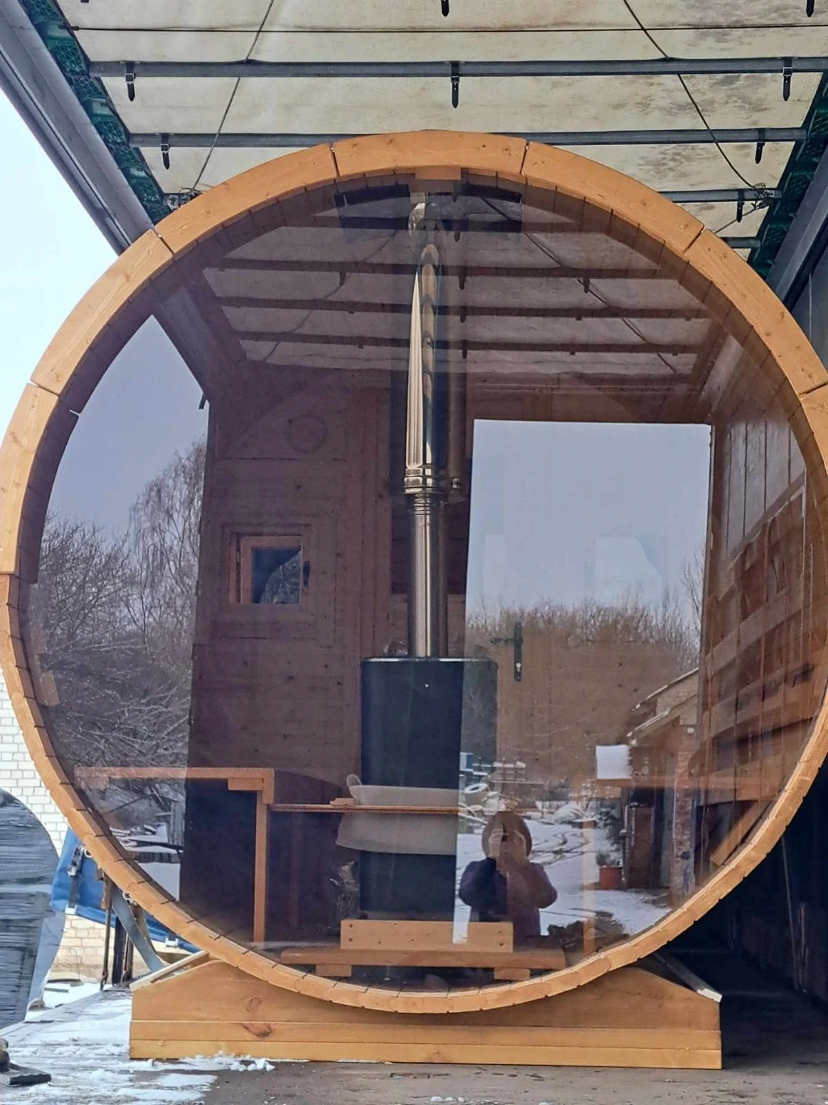 Tønnebadstue med helglass i gavlen og vedovn midt i rommet
